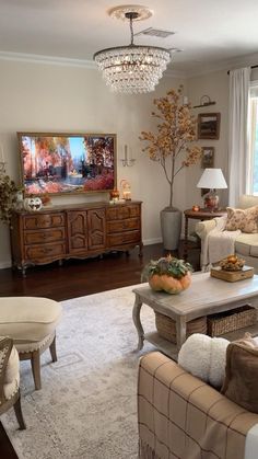 a living room filled with furniture and a chandelier hanging over the top of it