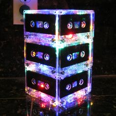 a stack of cassettes sitting on top of a table covered in lights and magnets