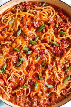 a skillet filled with spaghetti and meat sauce