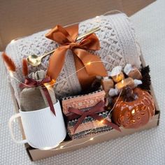 a gift box filled with coffee, cookies and other holiday treats sits on a bed