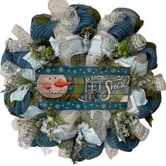 a snowman wreath with the words let it snow written in white and blue yarn