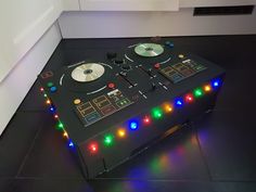 a table that has some lights on it and two turntables sitting on top of it