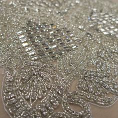 a close up view of the beading on a table cloth with silver sequins