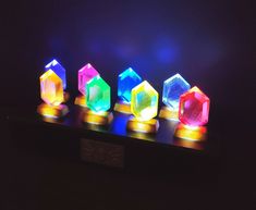 three different colored lights sitting on top of a wooden table next to a black wall