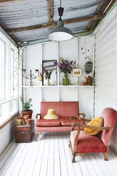 a living room with two couches and potted plants on the wall above them