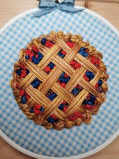 a blue and white checkered table cloth with a wooden basket on it that has red, white, and blue flowers in the center