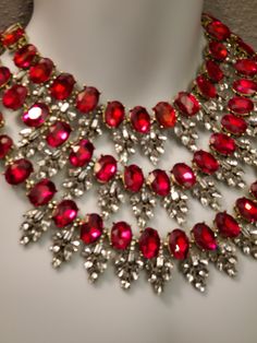 "Hello, welcome to Ken's Closet *My camera didn't like the red color* All red crystals are the same color. In the picture, they look like a mixture of red, pink, and orange. Today we have a beautiful 3 strand Ruby Red and Diamond Clear Crystal Necklace. The crystals are set in gold metal, they really bring out the color. Large crystals are accented by smaller Clear crystals. The necklace is appx 18\" long total. The hang is appx 5\" from the center top stand to the bottom 3rd strand. Crystals ar Red Bling Jewelry For Evening, Red Rhinestone Evening Jewelry, Red Rhinestone Evening Necklace, Red Rhinestone Evening Necklaces, Red Rhinestone Jewelry For Evening, Evening Red Jewelry With Rhinestones, Red Rhinestone Party Necklaces, Glamorous Red Crystal Necklaces, Red Rhinestone Necklaces For Evening