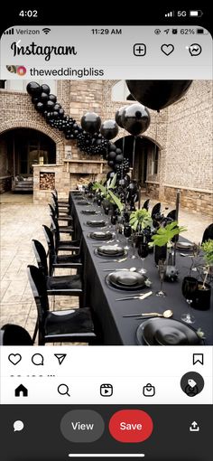 a long table set up with black plates and silverware for an elegant dinner party