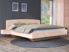 a bed sitting on top of a hard wood floor next to a wooden window sill