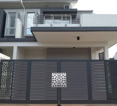 a house with an iron gate in front of it and a balcony on the second floor