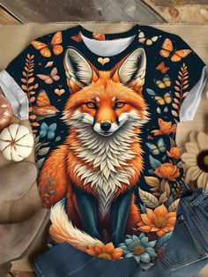 a t - shirt with an image of a fox and butterflies on it, sitting next to some pumpkins