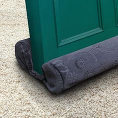 an image of a green door with a towel on the floor