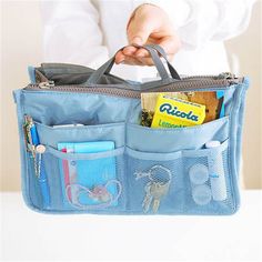 a person holding a blue bag with various items in it and the inside pocket open