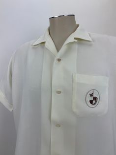 1950's rayon shirt with an embroidered crest on the patch pocket. This is a pale yellow rayon fabric. This shirt has white pearlized buttons a patch pocket and a loop collar. This shirt is in EXCELLENT VINTAGE CONDITION.. no real issues to note.. Label reads: PENNEY'S TOWNCRAFT machine washable MEN'S SIZE: LARGE 16 16-1/2 Neck To be certain of the size, check measurements below: Measurements: ( lying flat) From the top of the shoulder seam to shoulder seam: 19 inches Chest taken from under the a Classic Embroidered Cream Top, Classic Cream Embroidered Top, Vintage White Collared Camp Shirt, Vintage White Shirt With Camp Collar, Vintage Cream Collared Shirt, Vintage Hawaiian Shirts, Rayon Shirt, Butter Yellow, Vintage Hawaiian