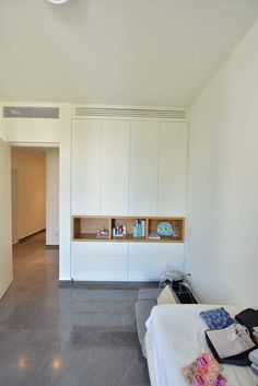 an empty bedroom with white cabinets and grey flooring