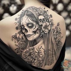 a woman's back with a skull and flowers tattoo on her upper half sleeve