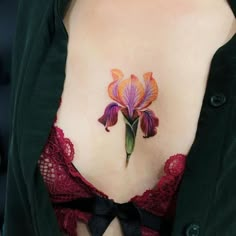 a woman with a tattoo on her stomach has a purple flower in the shape of a bow