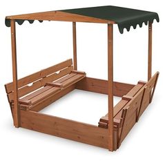 a wooden bed frame with a green canopy over it and two benches under the top