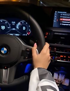 a person is driving a car with the steering wheel and dashboard lights on, while other electronic devices are visible in the background