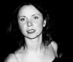 a black and white photo of a woman with dark hair, wearing a tank top