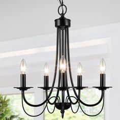 a black chandelier with five lights hanging from it's center and bottom