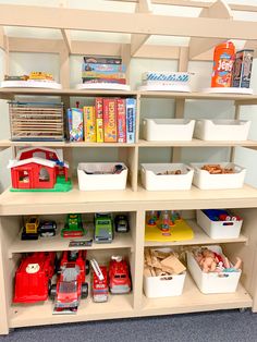 toy trucks and other toys sit on shelves in a playroom