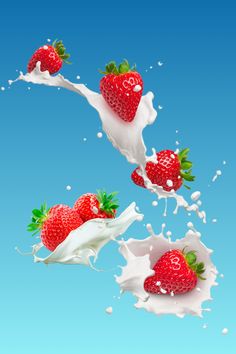 three strawberries falling into milk with splashing on the ground and blue sky in background