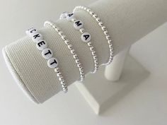 one name bracelet made with 4mm sterling silver beads bracelets are made on a durable stretch elastic cord please refer to our sizing guide before purchasing Classic Adjustable White Name Bracelet, Classic White Adjustable Name Bracelet, Customizable White Bracelets For Everyday, Classic White Bracelets For Everyday, White Classic Beaded Bracelets For Everyday, Classic White Name Bracelet As Gift, Elegant White Name Bracelet With Letter Beads, Flexible White Beaded Friendship Bracelet, Classic Adjustable Sterling Silver Stretch Bracelet