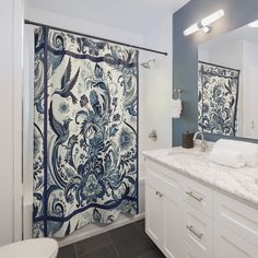 a blue and white shower curtain in a bathroom with marble counter tops on both sides