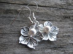 Choose your color pearl tropical Hibiscus flower earrings.  #hibiscusearrings #flowerearrings #beach #beachearrings #beachwedding #pearl #pearlearrings #personalized #personalizedearrings #bridesmaidearrings #bridesmaidgift #tropical #flowerearrings #under15 #abundantearthworks Antique Silver Nickel-free Earrings For Wedding, Nickel-free Antique Silver Earrings For Wedding, Nickel Free Antique Silver Wedding Earrings, Nickel-free Antique Silver Wedding Earrings, Silver Flower Drop Earrings For Bridesmaid Gift, Silver Flower Charm Earrings For Wedding, Handmade Silver Earrings For Bridesmaid Gift, Silver Sterling Silver Earrings For Bridesmaids, Hypoallergenic Silver Earrings For Bridesmaids