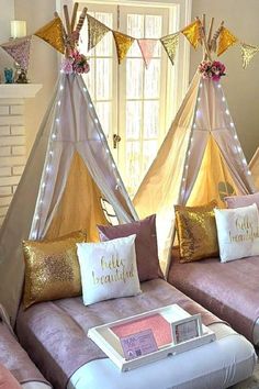 a living room with two couches covered in pillows and some kind of teepee