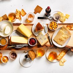 an assortment of cheeses and crackers on a wooden platter