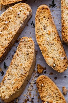 several pieces of bread on a sheet of parchment paper with seasoning sprinkles