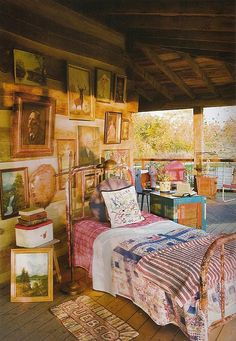 a bedroom with pictures on the wall and a bed in front of a large window