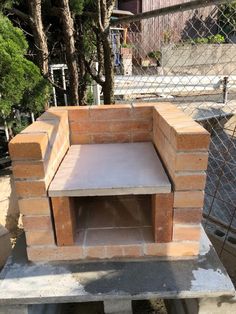 a brick fire pit sitting on top of a cement slab