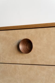 a close up of a drawer with a wooden knob