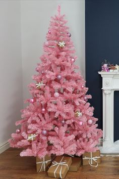 a pink christmas tree with presents under it