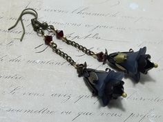 BLACK FLOWER EARRINGS  ▪️▪️▪️▪️▪️▪️▪️️▪️▪️▪️▪️▪️▪️ These elegant black gothic floral earrings are made with black vintage Lucite flowers. They have deep dark blood red Swarovski garnet crystals for beautiful sparkle when they move and are finished with antique bronze fish hook ear wires and ornate floral bead caps. They are very light weight and are perfect for special occasions, festivals and bridesmaids yet cute enough for everyday wear.  💜MATERIALS *Lucite Flowers  *Antique Bronze Findings * Lucite Flowers, Fairy Earrings, Gothic Floral, Earrings Gothic, Pink Gift Box, Bridesmaid Hair Accessories, Garnet Crystal, Dark Blood, Bohemian Accessories