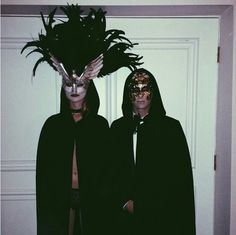 two people wearing masks standing next to each other