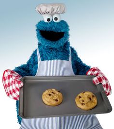 the cookie monster is holding a tray with two cookies on it