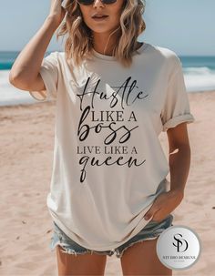 Elevate your style and motivation with our Hustle Like a Boss, Live Like a Queen shirt! This Inspirational Graphic Tshirt is perfect for the ambitious woman who knows how to balance hard work with living life to the fullest. Made from premium soft cotton, this Motivational Womens Shirt offers comfort and durability, making it a great addition to your casual wardrobe or a thoughtful gift for a friend. Care instructions:  * Wash items inside out in cold water.  * Do not bleach. * Do not dry clean. Summer Crew Neck T-shirt With Quote Print, White Summer T-shirt With Quote Print, Summer Cotton T-shirt With Quote Print, Summer Graphic Tee With Quote Print, Boss Shirt, Queen Shirt, Boss Shirts, Ambitious Women, Queen Tshirt