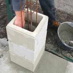 a man standing next to a cement block with some tools in it's hands