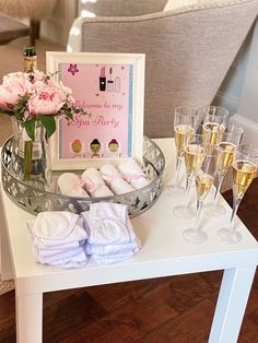 a table with champagne glasses and pink flowers on it next to a sign that says welcome to my big sister party