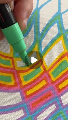 someone is drawing on the fabric with marker and pen, using colored pencils to create an abstract pattern