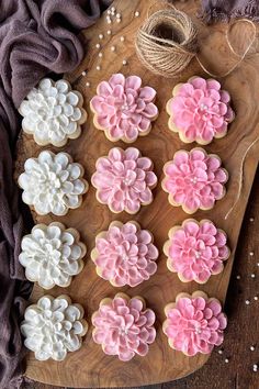 decorated cookies on a cutting board with twine and sprinkles in the shape of flowers