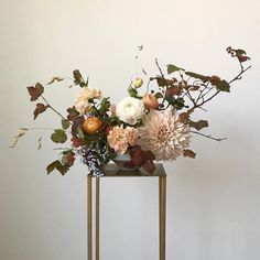 a vase filled with flowers sitting on top of a metal stand