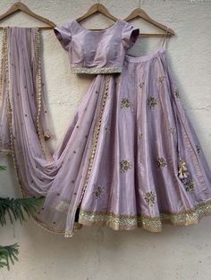 This radian red ruffled draped (pre-stitched) chiffon saree with ruffle detailing is paired with a mirror and pearl hand embroidered bustier blouse. Benaras Lehenga Designs, Cheap Eid Choli With Zari Weaving, Lavender Half Saree, Red Ruffle Saree, Lavender Outfits, Designer Choli, Bustier Blouse, Embroidered Bustier, Raw Silk Blouse