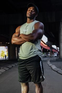 a man with his arms crossed standing in the street