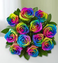 a bouquet of multicolored roses sitting on top of a table