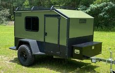 an off - road camper trailer is parked in the grass